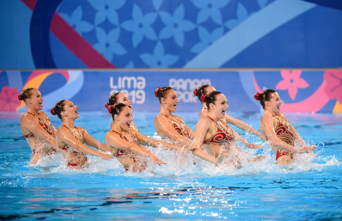 Huit nageuses lors de leur programme, elles ont de l'eau aux hanches. 