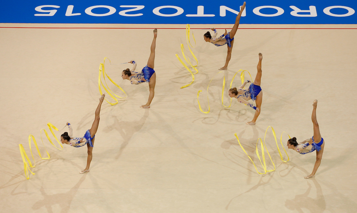 Des gymnastes effectue une routine de rubans par équipes.