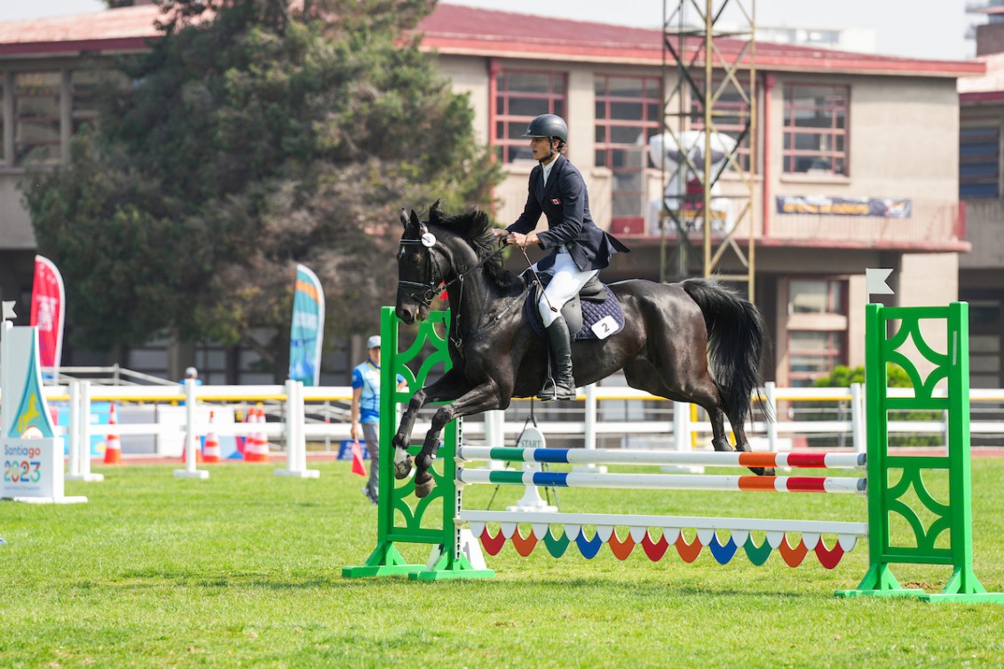 Une athlète effectue un saut sur un cheval. 