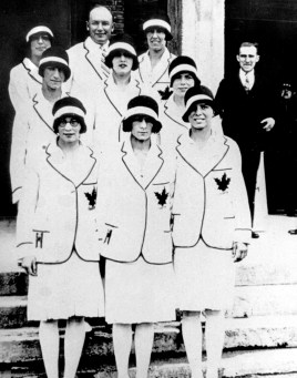Des femmes en uniformes blancs posent dans des marches.