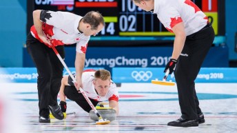 Trois joueurs de curling en action