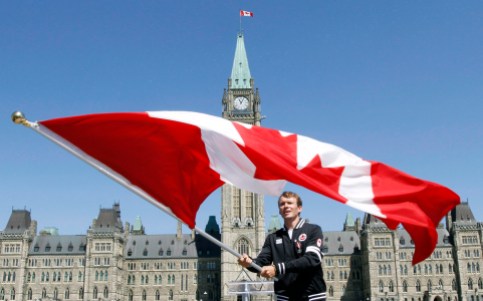 Simon Whitfield Le triathlète Simon Whitfield agite le drapeau canadien après l'annonce, sur la colline du Parlement à Ottawa, qu'il serait le porte-drapeau de l'équipe du Canada lors de la cérémonie d'ouverture des Jeux Olympiques de Londres 2012. LA PRESSE CANADIENNE/Fred Chartrand