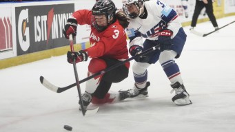 Jocelyne Larocque joue la rondelle avec un genou sur la glace.