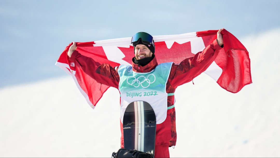 Le planchiste Max Parrot brandit le drapeau du Canada suite à sa victoire aux Jeux olympiques