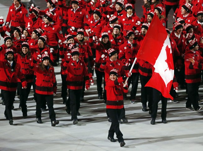 Hayley Wickenheiser du Canada porte le drapeau canadien lors de la cérémonie d'ouverture des Jeux olympiques d'hiver de 2014 à Sotchi, en Russie, le vendredi 7 février 2014. (AP Photo / Petr David Josek)