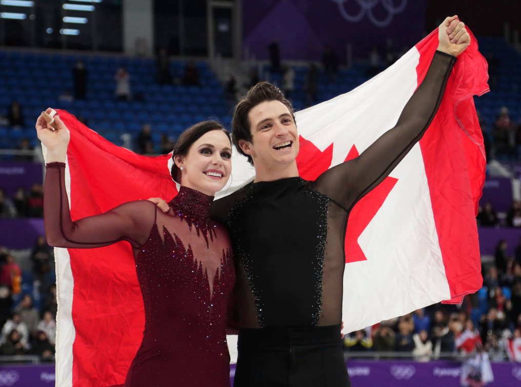 Tessa Virtue et Scott Moir tiennent le drapeau canadien