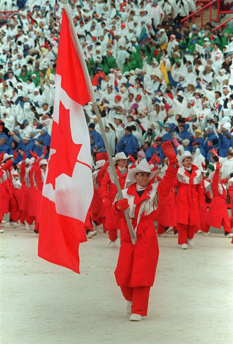 World figure skating champion Brian Orser carries the Canadian flag as he leads the Canadian Olympic team into McMahon Stadium in Calgary during the opening ceremonies of the XV Olympic Winter Games on February 13, 1988. THE CANADIAN PRESS/Paul Chiasson