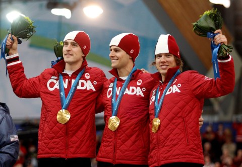 Denny Morrison, Lucas Makowsky, au centre, et Mathieu Giroux, à droite, se retrouvent sur le podium après avoir remporté la médaille d'or à la poursuite masculine en patinage de vitesse aux Jeux olympiques de Vancouver 2010 à Vancouver, Colombie-Britannique, le samedi 27 février 2010. (AP Photo / Matt Dunham)