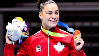 Une boxeuse sur le podium montre sa médaille