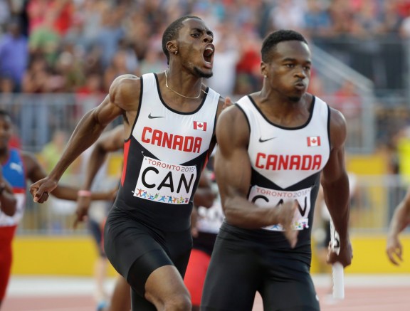 Canada's Brendon Rodney, left, screams after handing off the baton to Aaron Brown in the finals of the men's 4x100 meter relay at the Pan Am Games in Toronto, Saturday, July 25, 2015. Canada won the gold medal. (AP Photo/Mark Humphrey)