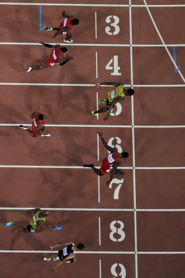 Andre De Grasse (couloir neuf) se penche pour capturer le bronze alors que Usain Bolt (5) et Justin Gatlin (7) se battent pour l’or et l’argent dans les derniers moments de la finale du 100 m aux Championnats du monde d’athlétisme de l’IAAF à Beijing en Chine le 23 août 2015.