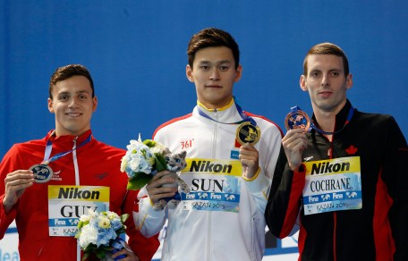 Ryan Cochrane en compagnie du Chinois Sun Yang (au centre) et de l'Anglais James Guy durant la cérémonie des médailles de l'épreuve du 400 m style libre aux Championnats du monde aquatique de la FINA à Kazan, en Russie, le 2 août 2015. (AP Photo/Sergei Grits)