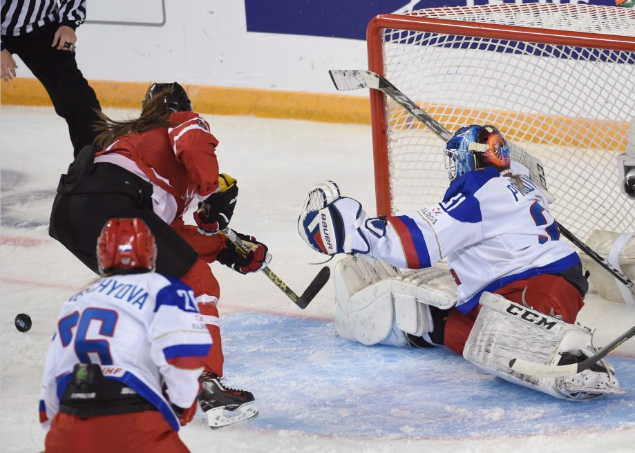 Rebecca Johnston, en rouge,essaie de tirer avantage d'un rebond devant la gardienne russe Ana Prugova (31) en première période du match Canada-Russie au Mondial de hockey féminin, le 29 mars 2016. THE CANADIAN PRESS/Ryan Remiorz