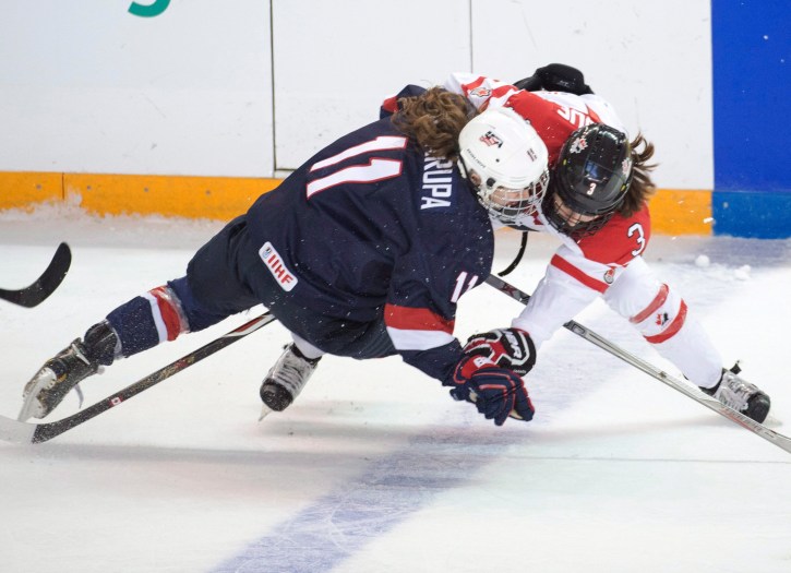Jocelyn Larocque (3) effectue une mise en echec sur Haley Skarupa des États-Unis lors de la première période en finale de Mondial de hockey féminin, à Kamloops, le 4 avril 2016. THE CANADIAN PRESS/Ryan Remiorz