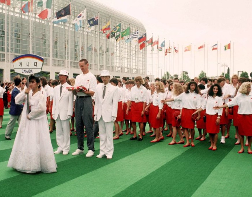 Romel Raffin (avec drapeau) et l'équipe olympique canadienne participent à la levée du drapeau canadien aux Jeux olympiques de Séoul de 1988. (Photo PC/AOC)