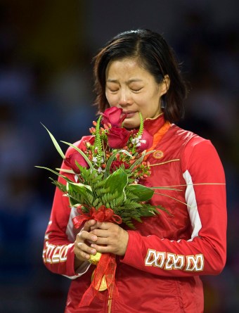 Une athlète tient des fleurs sur un podium