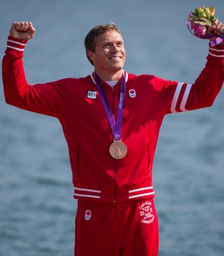 Un athlète célèbre sa médaille les poings dans les airs