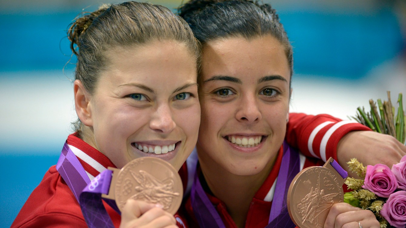 Deux athlètes montrent leur médailles de bronze à la caméra.