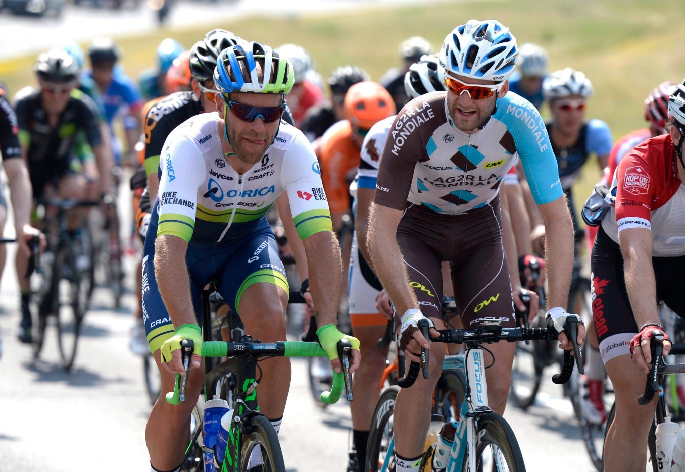 UCI WorldTour riders Svein Tuft (left) and Hugo Houle talk as they ride in the peloton during the elite and under-23 cycling race at the Canadian Road Championships, Sunday, June 26, 2016 in Ottawa. THE CANADIAN PRESS/Justin Tang