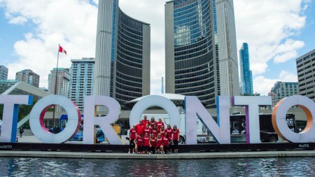 L’équipe canadienne de rugby devant le signe de « Toronto » au Nathan Phillips Square, le 26 juillets 2016. (Tavia Bakowski/COC)