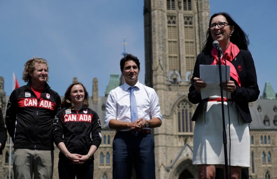Curt Harnett, Rosie MacLennan, Justin Trudeau et Tricia Smith (au micro) lors du dévoilement du porte-drapeau à la Colline du parlement, le 21 juillet 2016 à Ottawa.