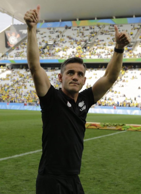 John Herdman lève les bras dans les airs.