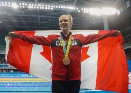 Hilary Caldwell avec le drapeau canadien et sa médaille de bronze obtenue au 200 m dos aux Jeux de Rio. 12 août 2016. Photo Mark Blinch