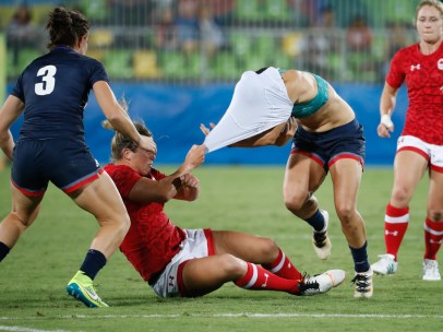 Une joueuse de la Grande-Bretagne est rabattue au sol par une joueuse canadienne lors du match pour la médaille de bronze aux Jeux de Rio. 8 août 2016 (Photo/Mark Blinch)
