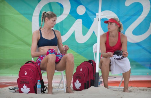 Les joueuses canadiennes de volleyball de plage Heather Bansley (rouge) et Sarah Pavan (noir), lors d’une séance d’entraînement contre un tandem Brésilien aux Jeux olympiques de 2016, à Rio. COC Photo by Jason Ransom