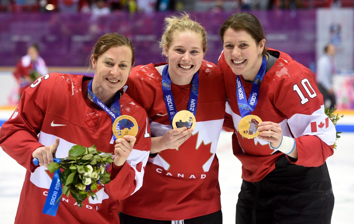 Trois joueuses avec leur médaille d'or autour du cou.