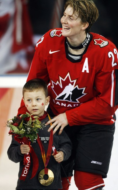 Hayley Wickenheiser du Canada, et son fils Noah pendant la cérémonie des médailles aux Jeux olympiques d'hiver de 2006, le 20 février 2006 , À Turin, en Italie. (AP Photo / Gene J. Puskar)