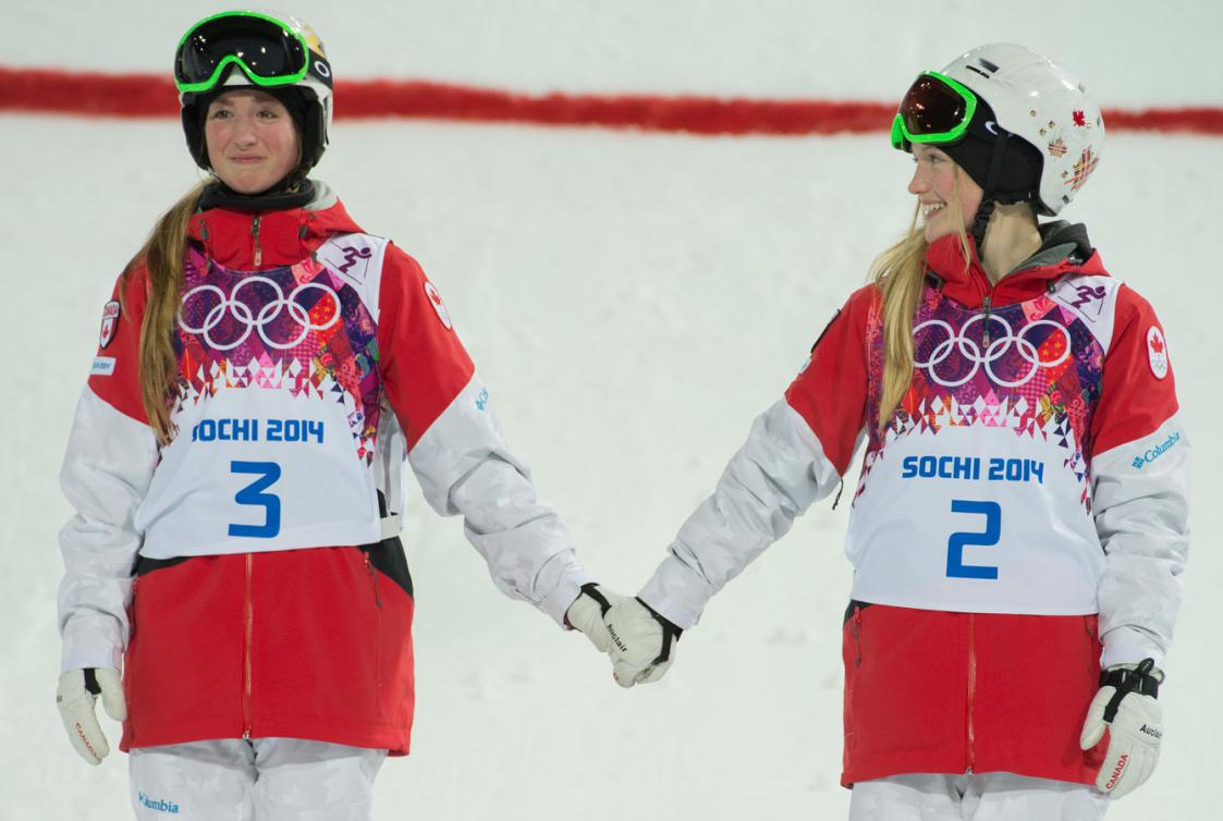 Les deux soeurs se tiennent la main sur le podium