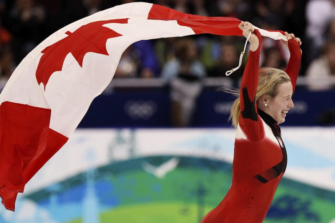 marianne St-Gelais fait un tour de piste sur la glace en portant le drapeau canadien, è Vancouver 2010.