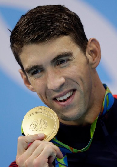 Michael Phelps Michael Phelps et sa médaille d'or après la finale masculine de relais 4 x 100 mètres lors des compétitions de natation aux Jeux olympiques d'été de 2016 à Rio de Janeiro, le 14 août 2016. (AP Photo / Michael Sohn)