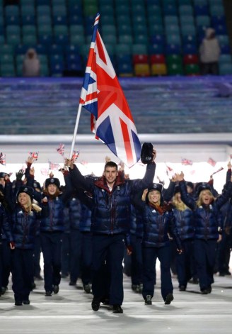 Jon Eley of Britain porte le drapeau national alors qu'il mène l'équipe lors de la cérémonie d'ouverture des Jeux olympiques d'hiver de 2014 à Sotchi, en Russie, le vendredi 7 février 2014. (AP Photo / Mark Humphrey)