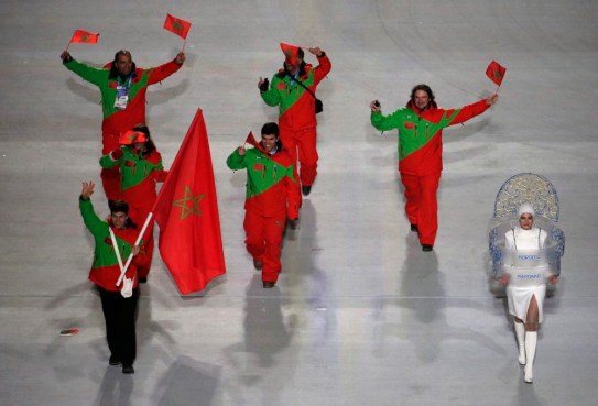 Adam Lamhamedi du Maroc détient son drapeau national et entre dans le stade avec ses coéquipiers lors de la cérémonie d'ouverture des Jeux olympiques d'hiver de 2014 à Sotchi, en Russie, le vendredi 7 février 2014. (AP Photo / Charlie Riedel)