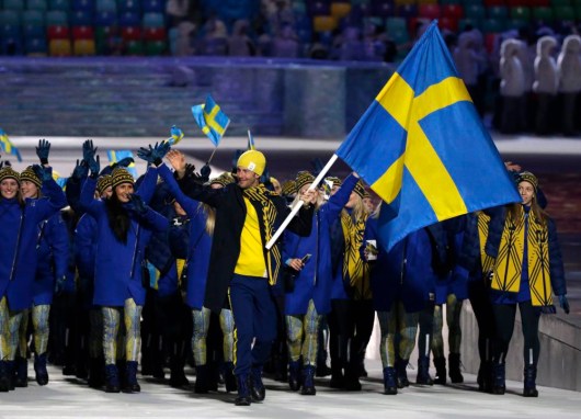 Anders Soedergren de Suède porte le drapeau national lors de la cérémonie d'ouverture des Jeux olympiques d'hiver de 2014 à Sotchi, en Russie, le vendredi 7 février 2014. (AP Photo / Mark Humphrey)
