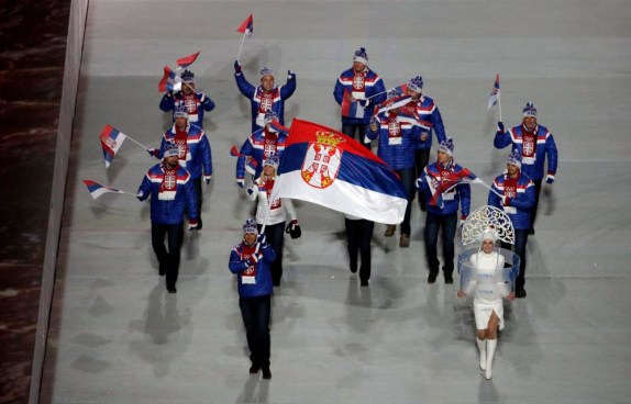 Milanko Petrovic de Serbie porte le drapeau national lors de la cérémonie d'ouverture des Jeux olympiques d'hiver de 2014 à Sotchi, en Russie, le vendredi 7 février 2014. (AP Photo / Charlie Riedel)