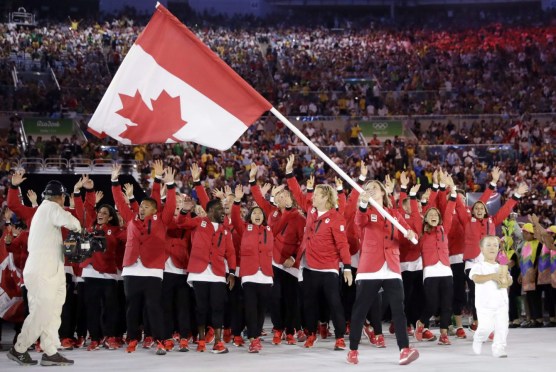 Rosie MacLennan porte le drapeau du Canada lors de la cérémonie d'ouverture des Jeux olympiques d'été de 2016 à Rio de Janeiro, au Brésil, le vendredi 5 août 2016. (Photo AP / David J. Phillip)