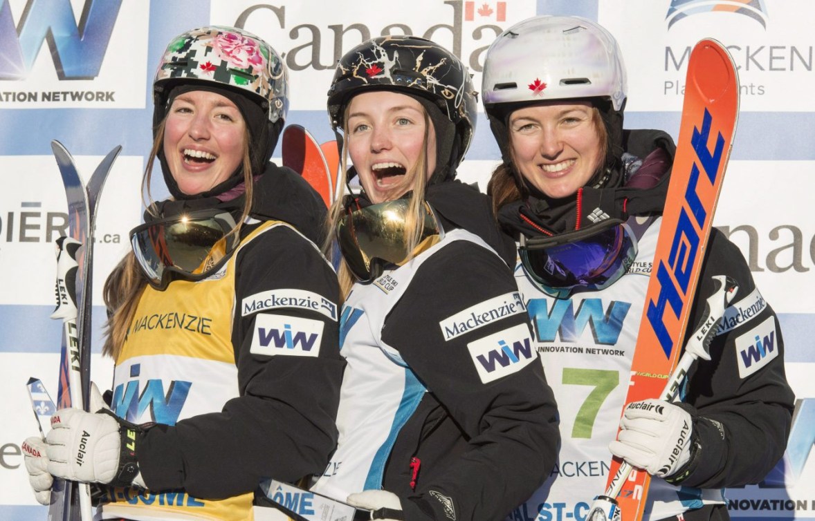 Chloé, Justine et Maxime Dufour-Lapointe posent sur un podium