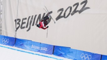 Un skieur acrobatique effectue un saut sur la demi-lune