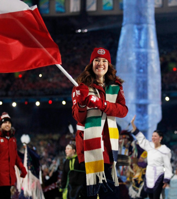 Clara Hughes porte le drapeau canadien.