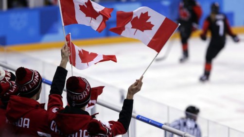 Les fans qui brandissent le drapeau canadien durant une partie préliminaire de hockey sur glace féminin du Canada contre la Finlande aux Jeux olympiques d'hiver de PyeongChang. Le 13 février 2018. (AP Photo/Frank Franklin II)
