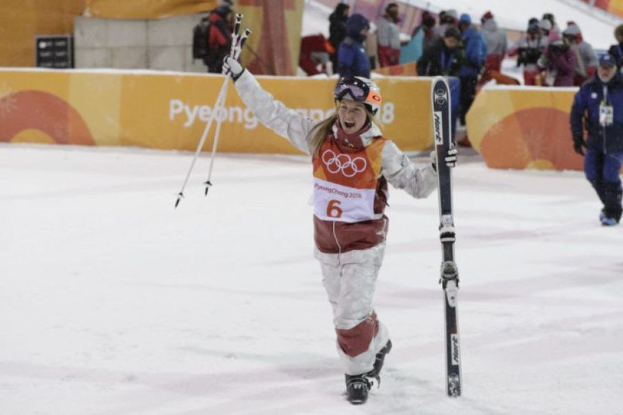 Justine Dufour-Lapointe en bas de la pente, les skis dans la main gauche et les bâtons dans la main droite.