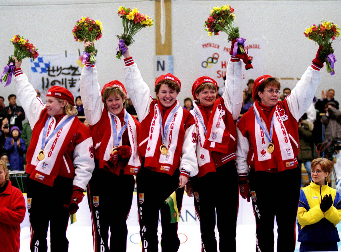 Des athlètes sur le podium avec des bouquets de fleurs