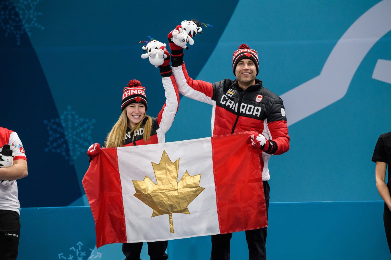 Deux athlète sur un podium avec des toutous et un drapreau