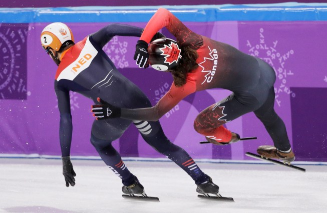 Samuel Girard se fait donner un coup de coude au relais 5000 m - hommes, aux Jeux olympiques de PyeongCHang 2018, le 13 février 2018. (AP Photo/David J. Phillip)