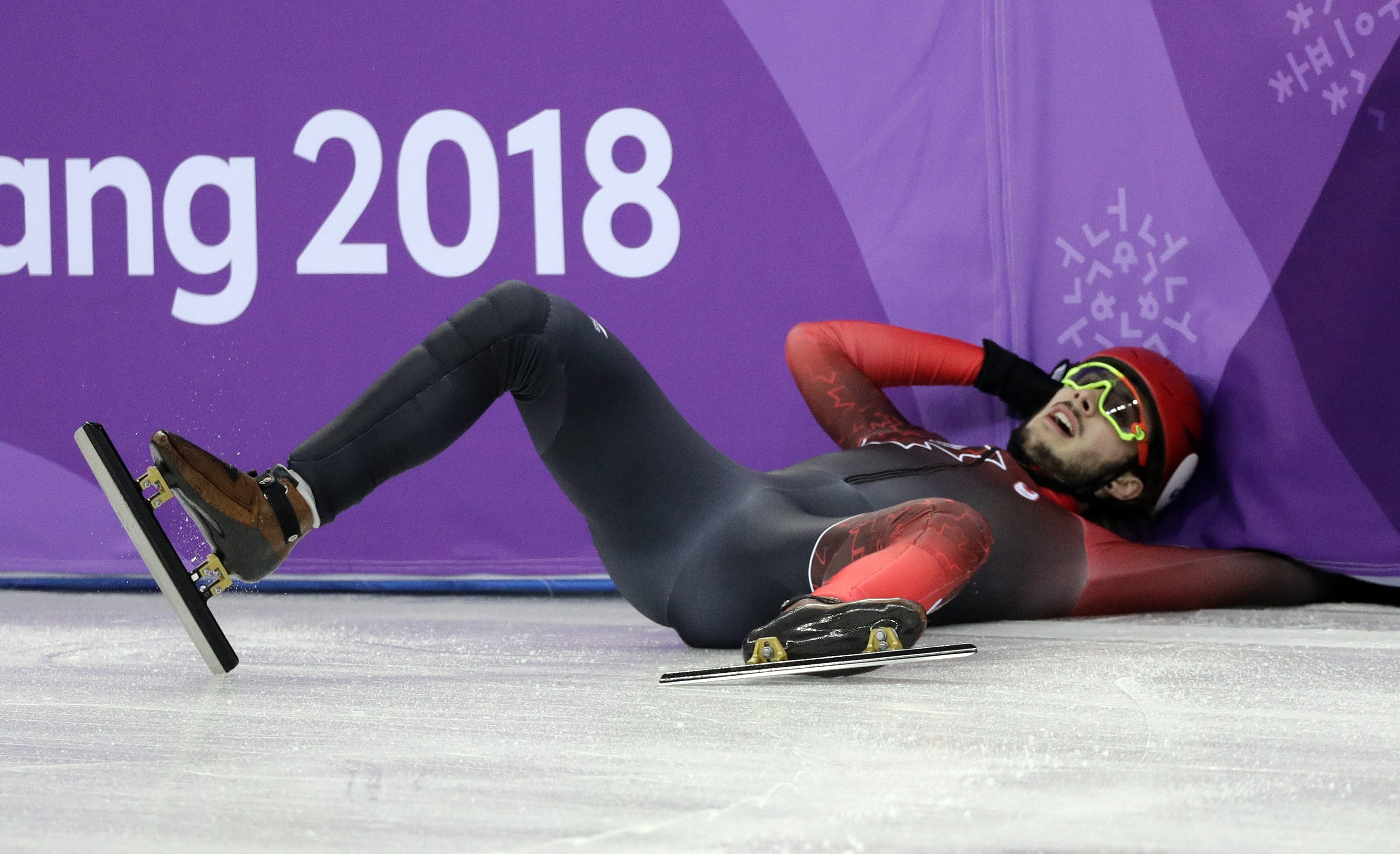 Samuel Girard est au sol après sa chute au relais 5000 m - hommes, aux Jeux olympiques de PyeongCHang 2018, le 13 février 2018. (AP Photo/David J. Phillip)