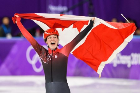 Kim Boutin défile avec le drapeau canadien après avoir gagné le bronze en finale du 1500 m. (Photo par Vincent Ethier/COC)