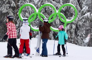 Quatre enfants en ski, les anneaux olympiques en arrière-plan